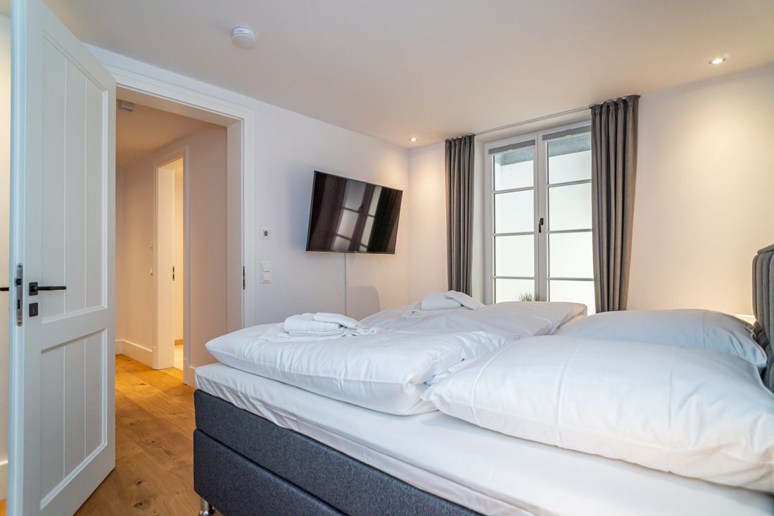Helles Schlafzimmer, Doppelbett mit Fernseher