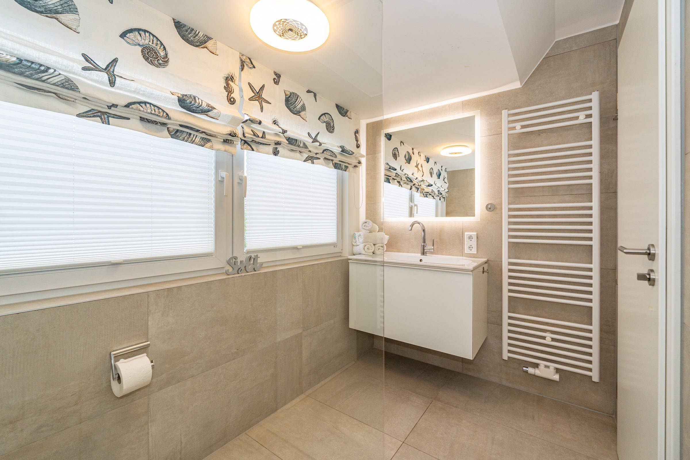 helles Badezimmer, Waschbecken mit Spiegel, Fenster, Heizung