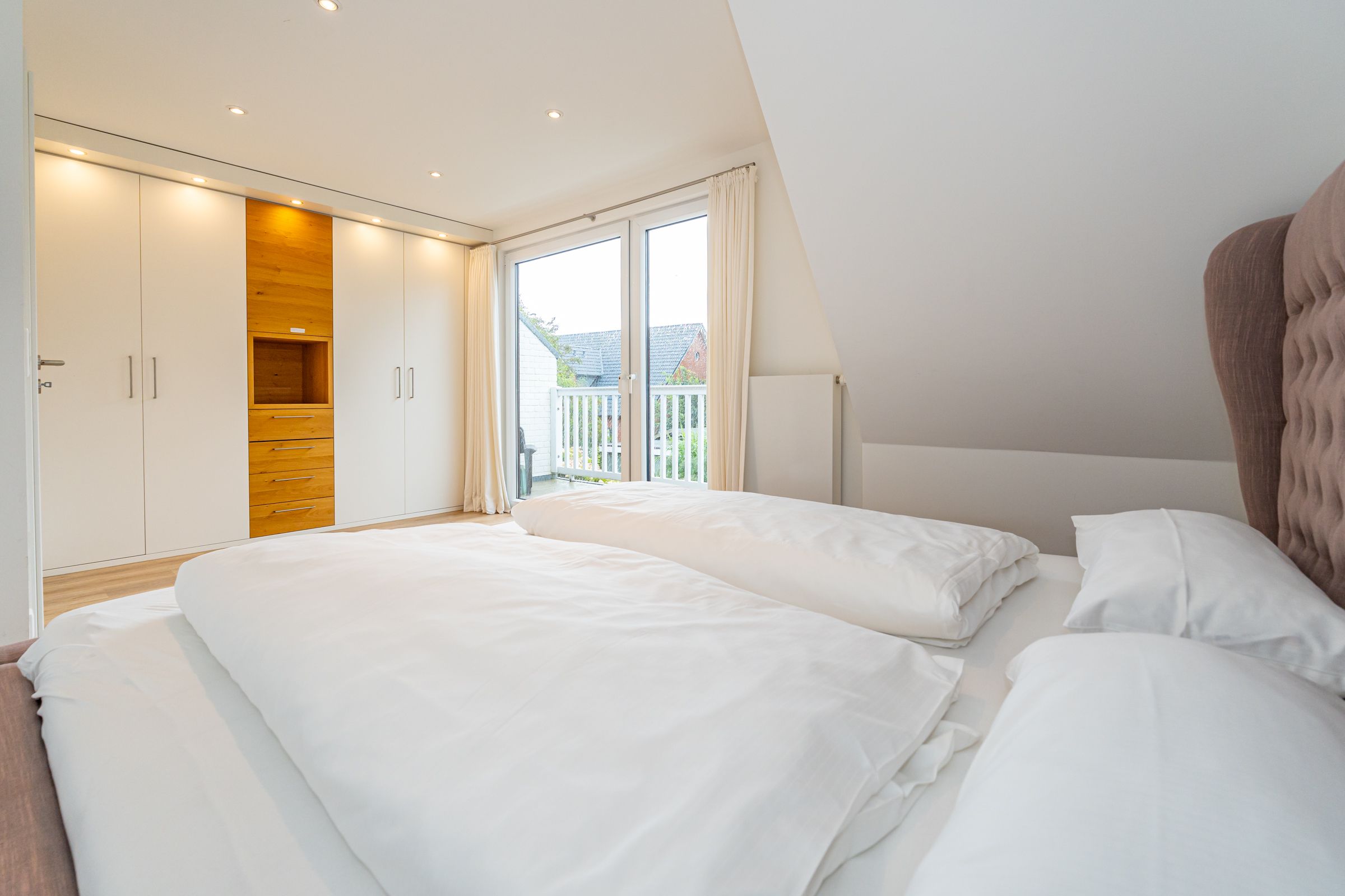 helles Schlafzimmer, Doppelbett, Kleiderschrank, Türen zum Balkon