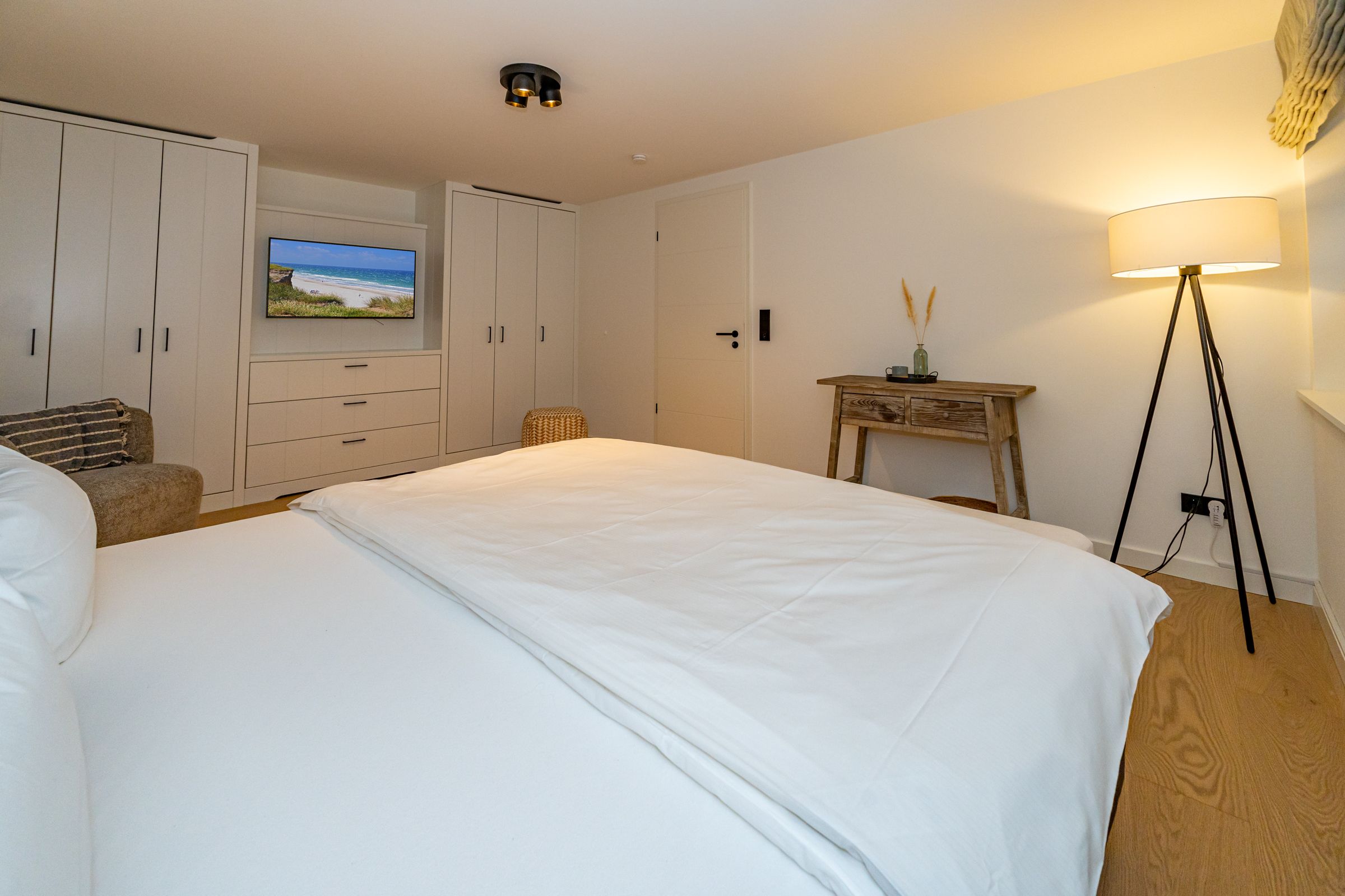 Schlafzimmer mit Doppelbett, Einbauschrank und Fernseher.