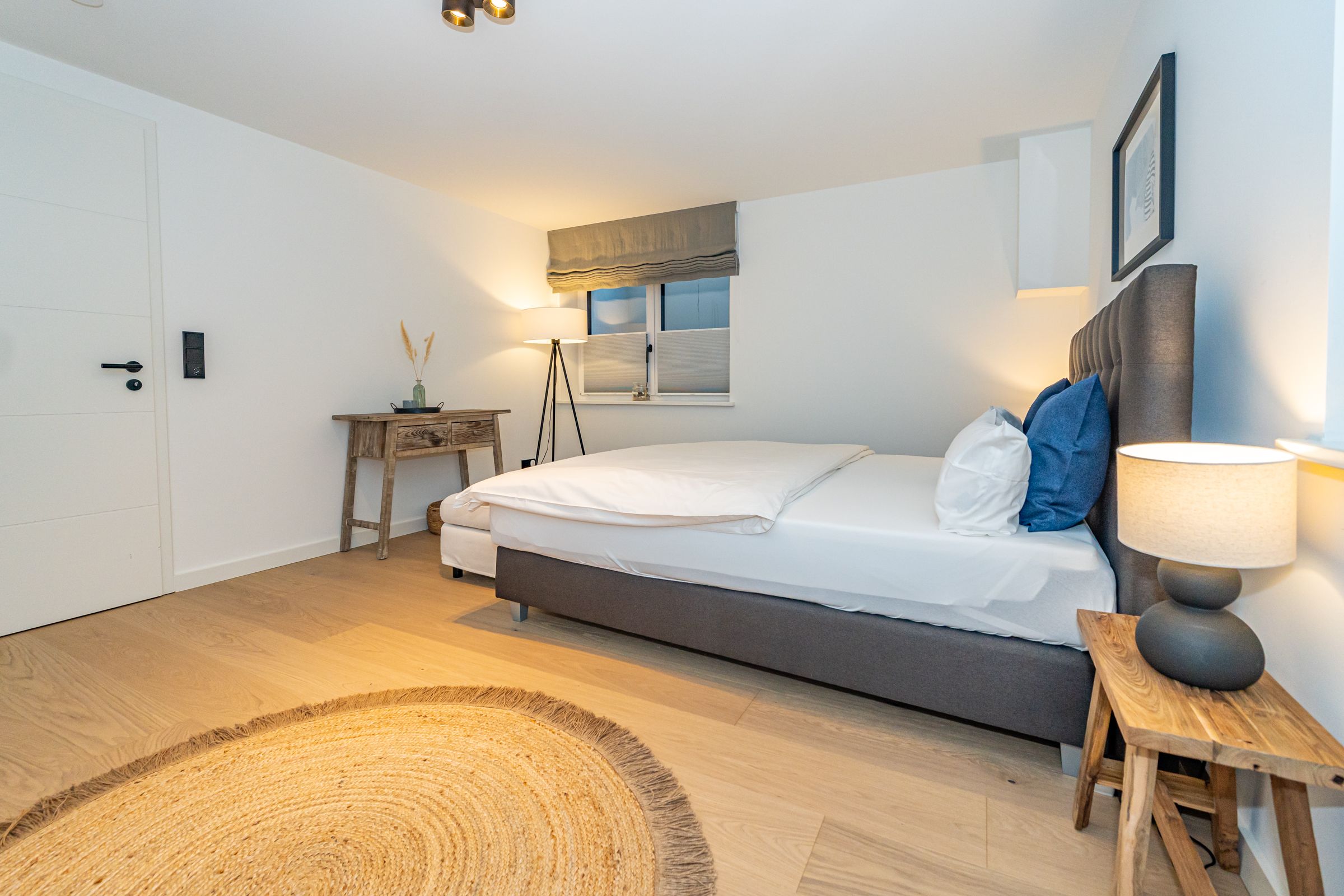 Schlafzimmer mit Doppelbett und Fenster.