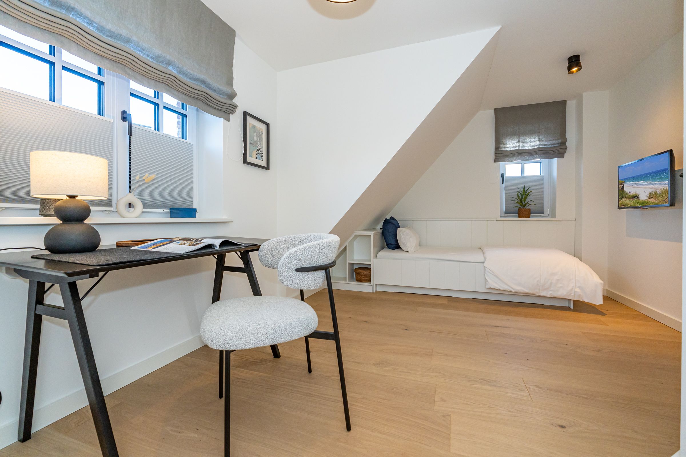 geräumiges Schlafzimmer mit Einzelbett, Schreibtisch und Blick in den Garten