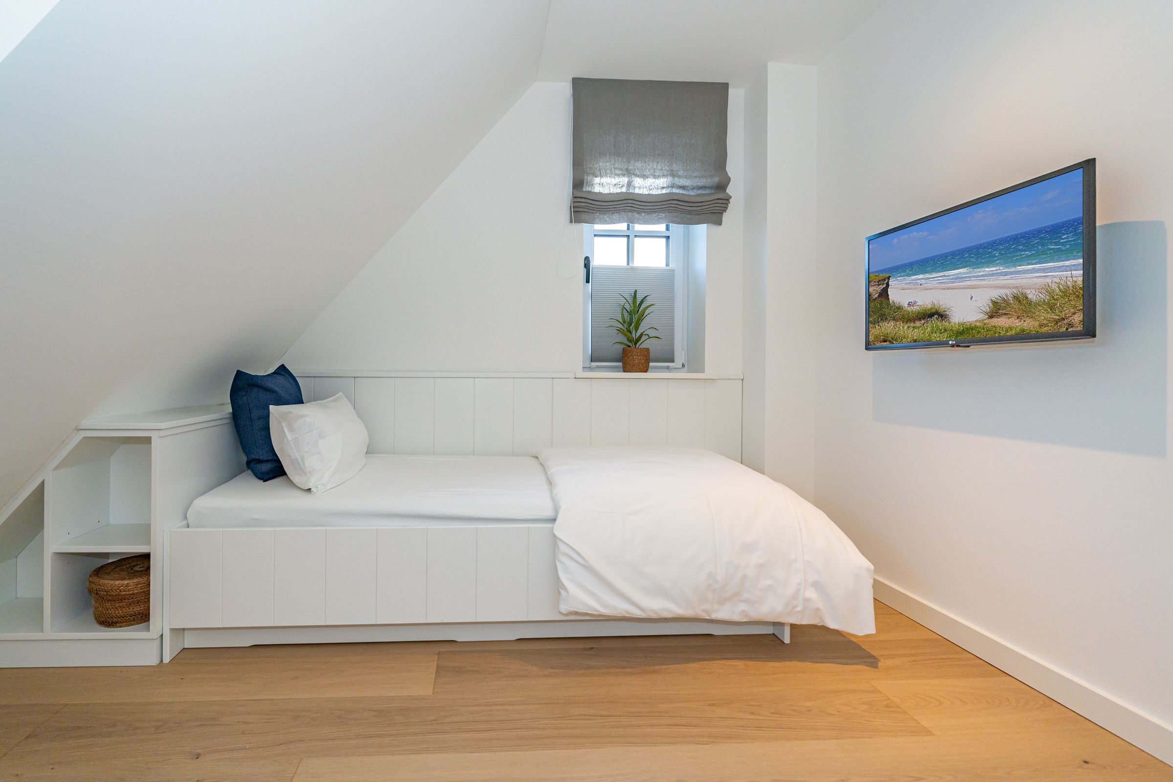 Schlafzimmer mit Einzelbett und Blick auf TV