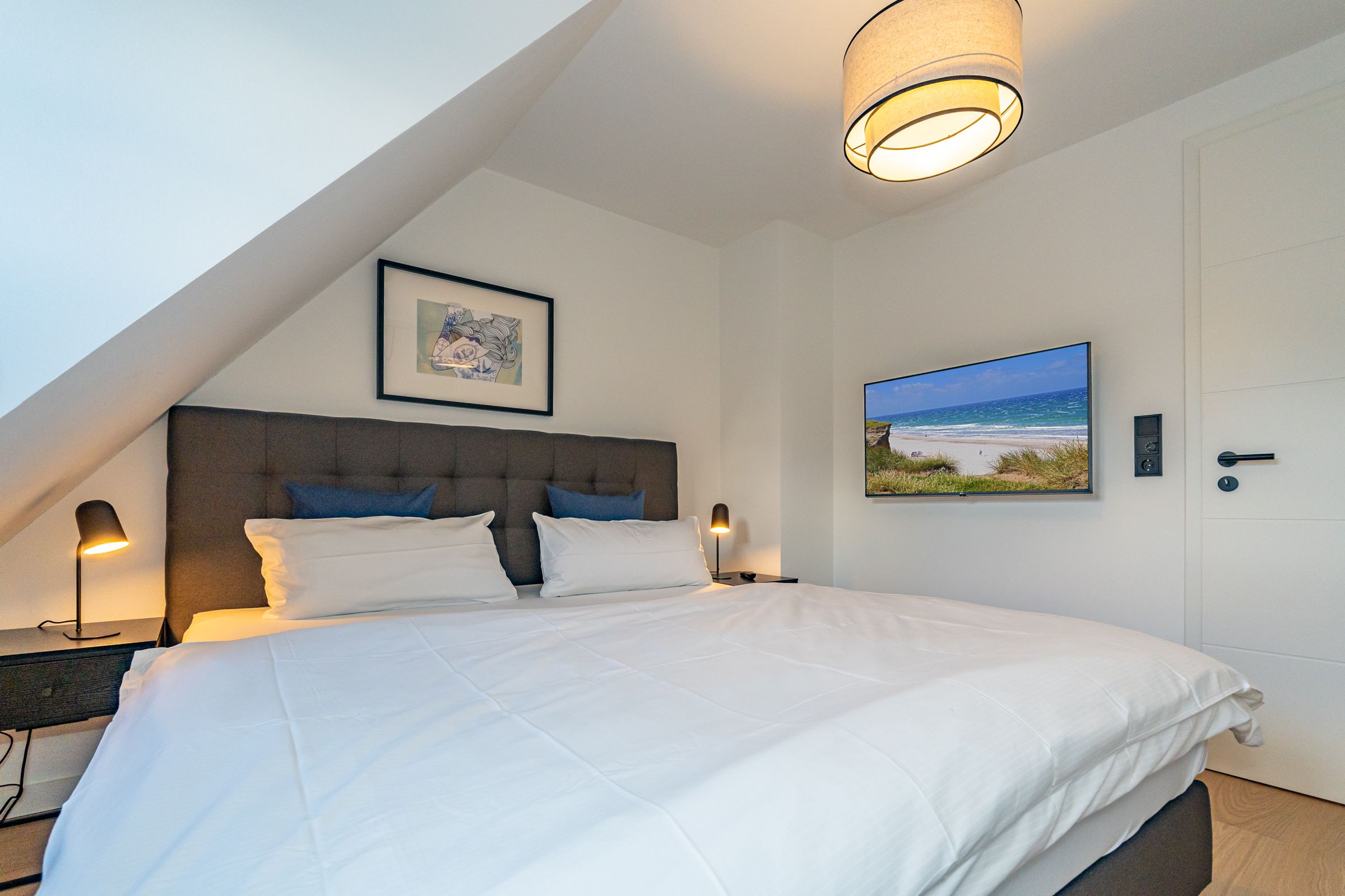 Schlafzimmer mit Doppelbett und TV