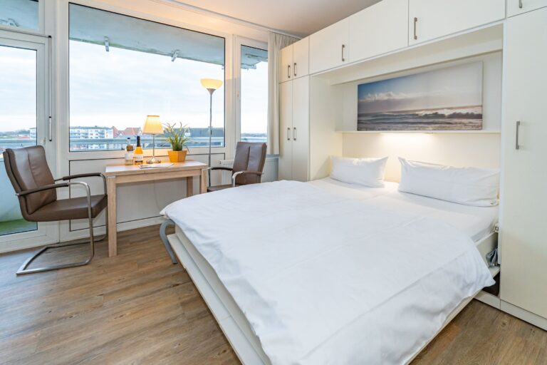 Doppelschrankbett mit Tisch und zwei Stühlen sowie Blick auf Westerland