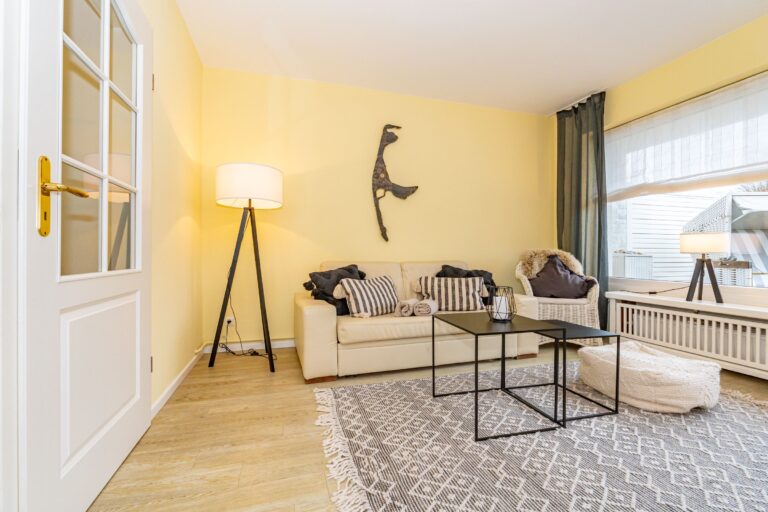 Blick auf den Wohnbereich mit Sofa und Syltsilhouette.