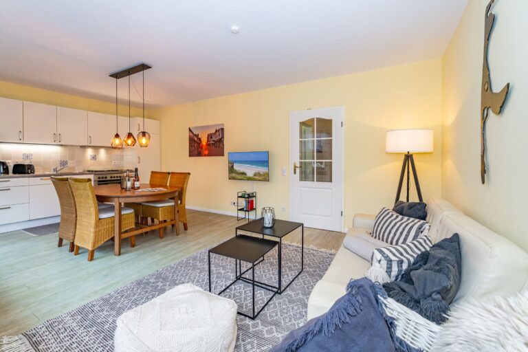 Sofa mit Couchtisch und Hocker. Über dem Sofa die Silhouette von Sylt