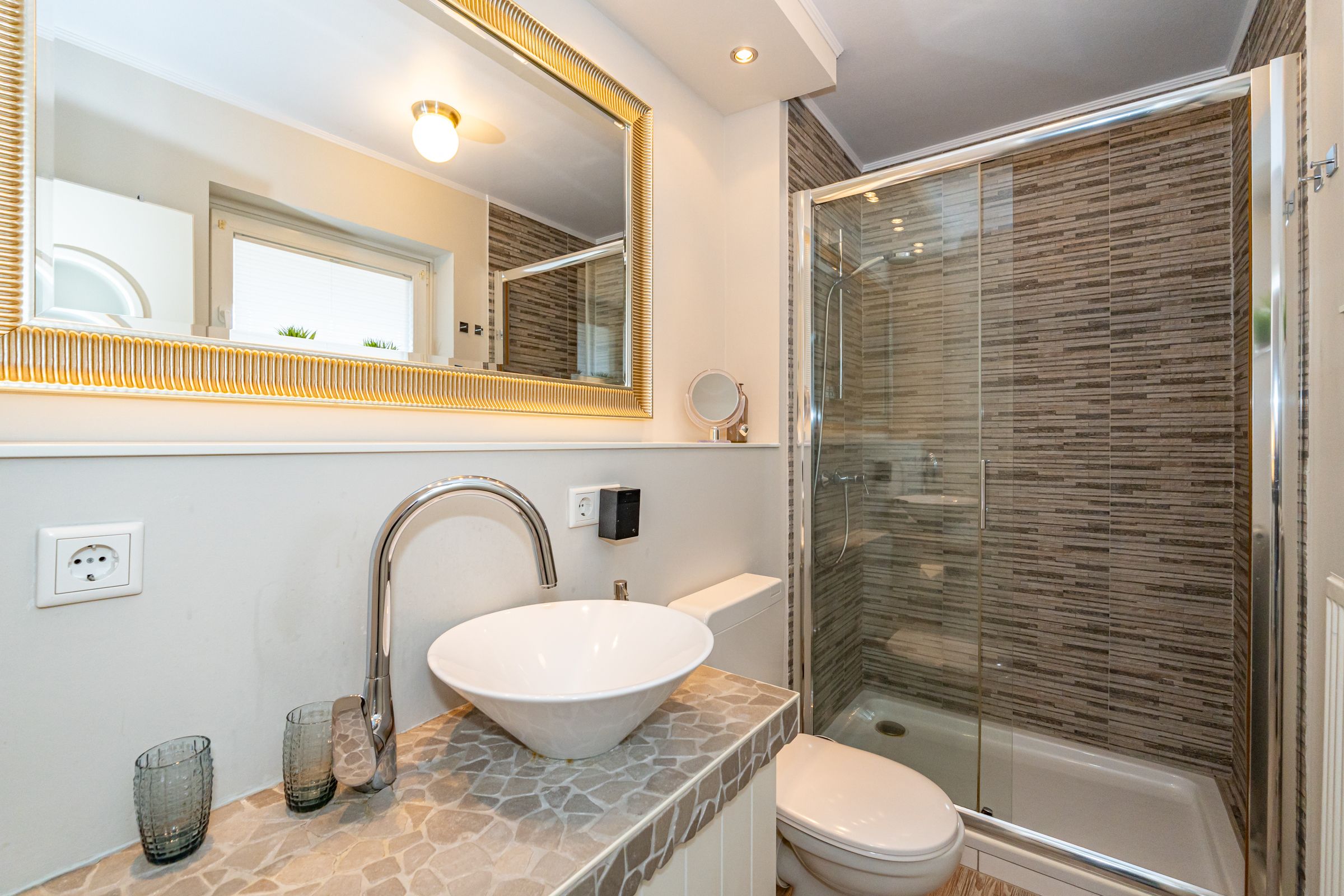 Badezimmer mit Waschbecken, WC und Dusche.