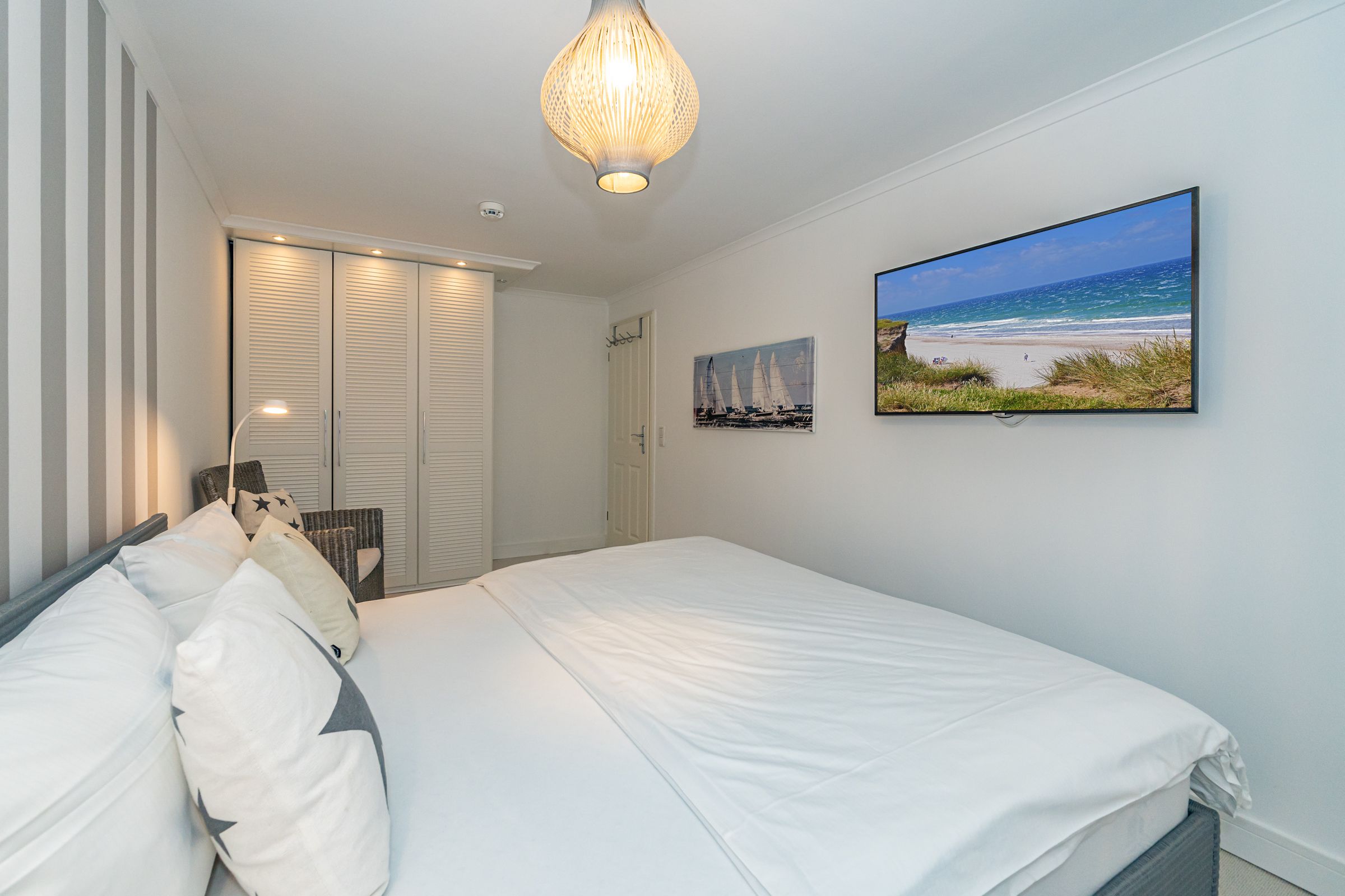 Schlafzimmer mit Doppelbett und TV. Im Schlafzimmer befindet sich der Kleiderschrank