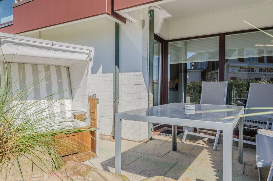 Terrasse mit Strandkorb und Gartenmöbeln aus Aluminium
